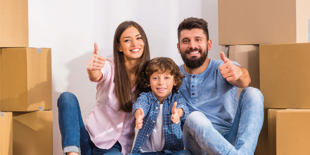 Happy young couple with their kid sitting next to moving boxes at their new home - How to Improve Cash Flow on Rental Properties - DG Pinnacle Commercial Loans - Miami Mortgage Lender