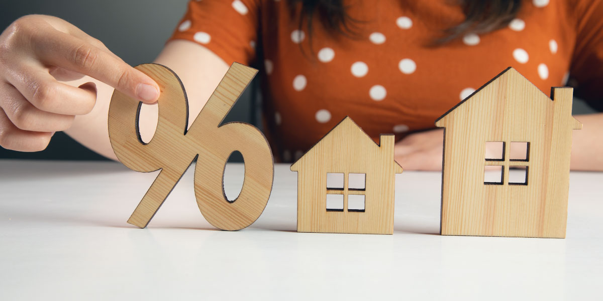 Female holding home model and wooden sale percentage sign - Benefits of Soft Money Loans for Investment Properties - DG Pinnacle Commercial - Miami Mortgage Lender