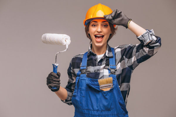 Repairer woman with painting roller and helmet | Best 2022 Markets for Ground Up Construction Loans | DG Pinnacle Commercial - Miami Mortgage Lender